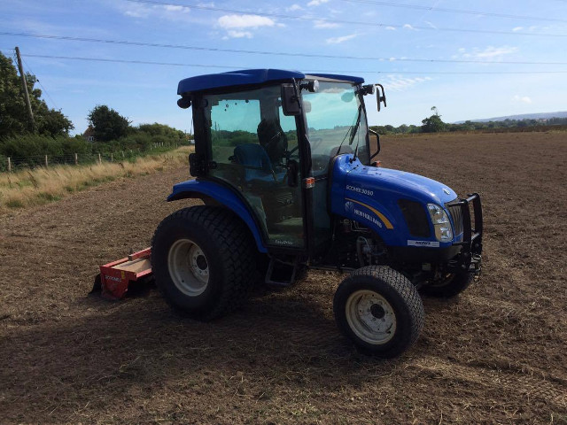 Tractor with power harrow in field